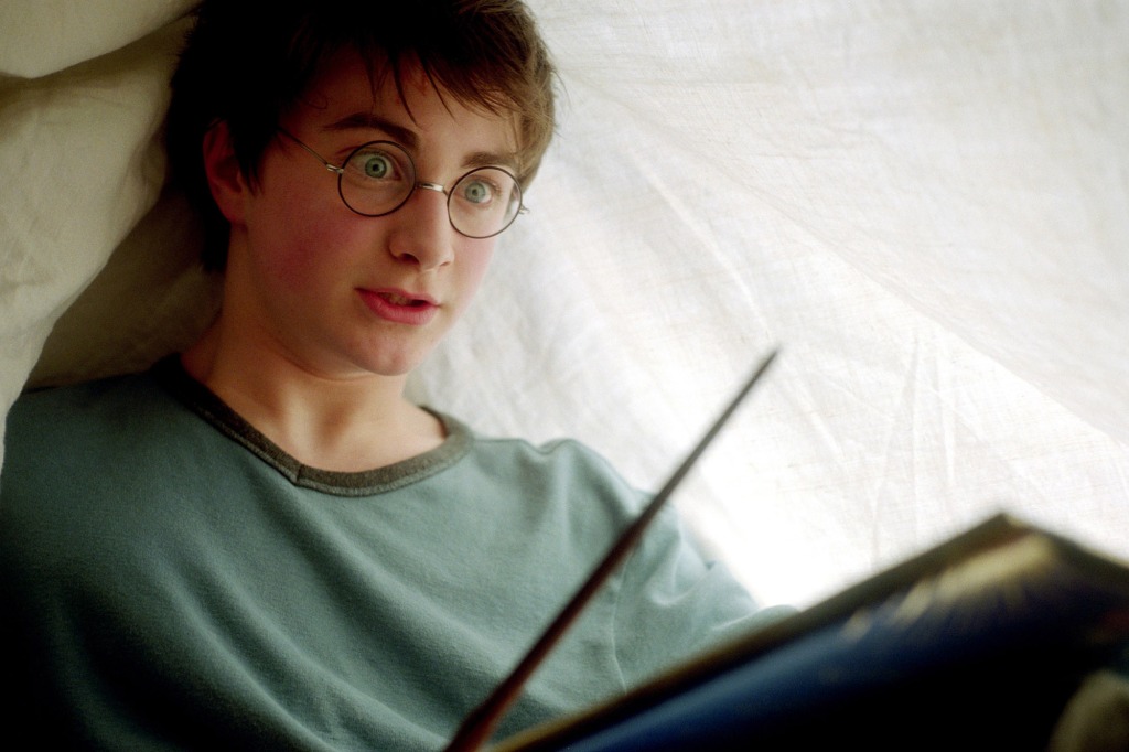 Harry Potter practices his spells underneath a blanket.
